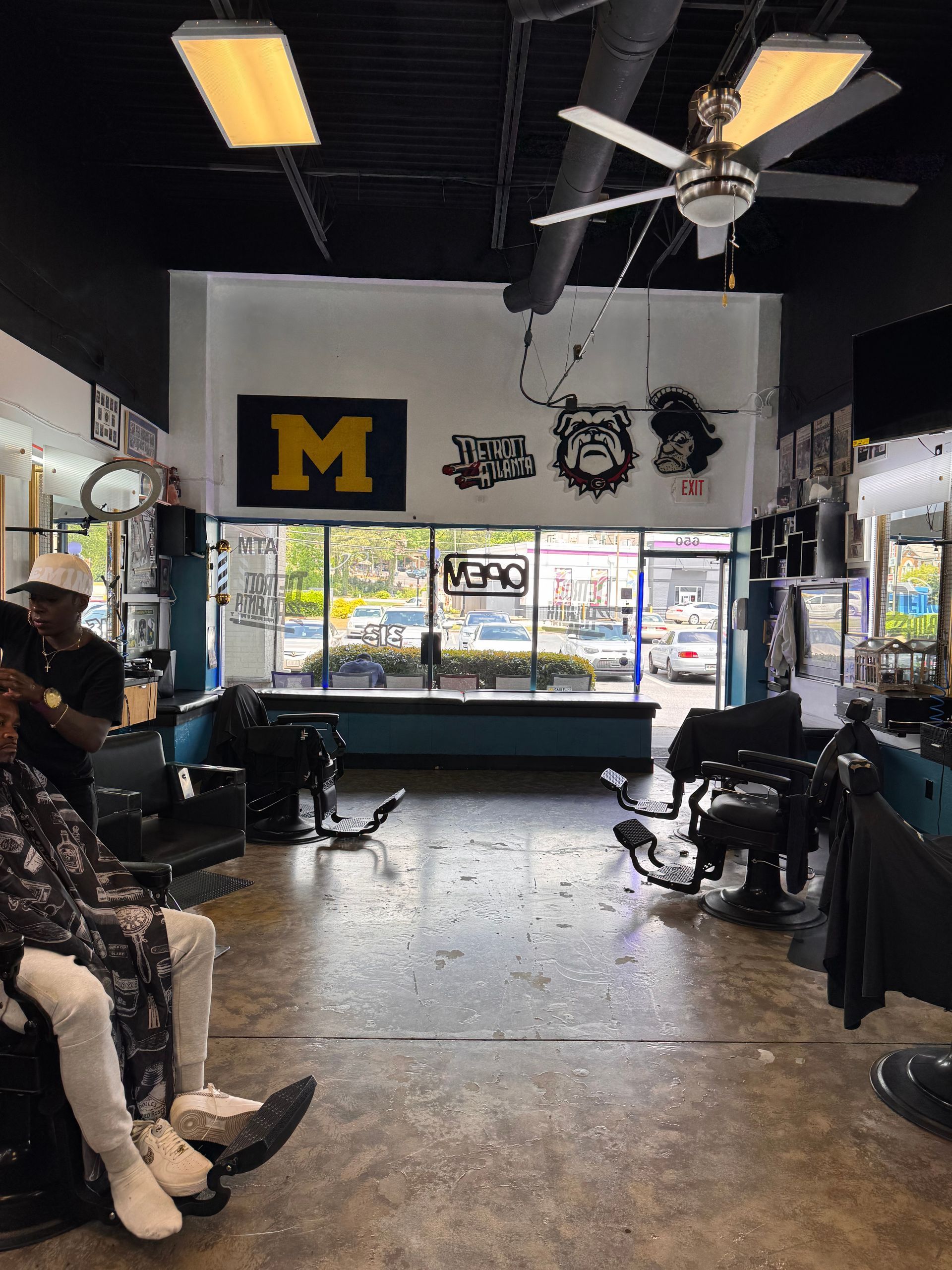 A barber shop with a large m on the wall.