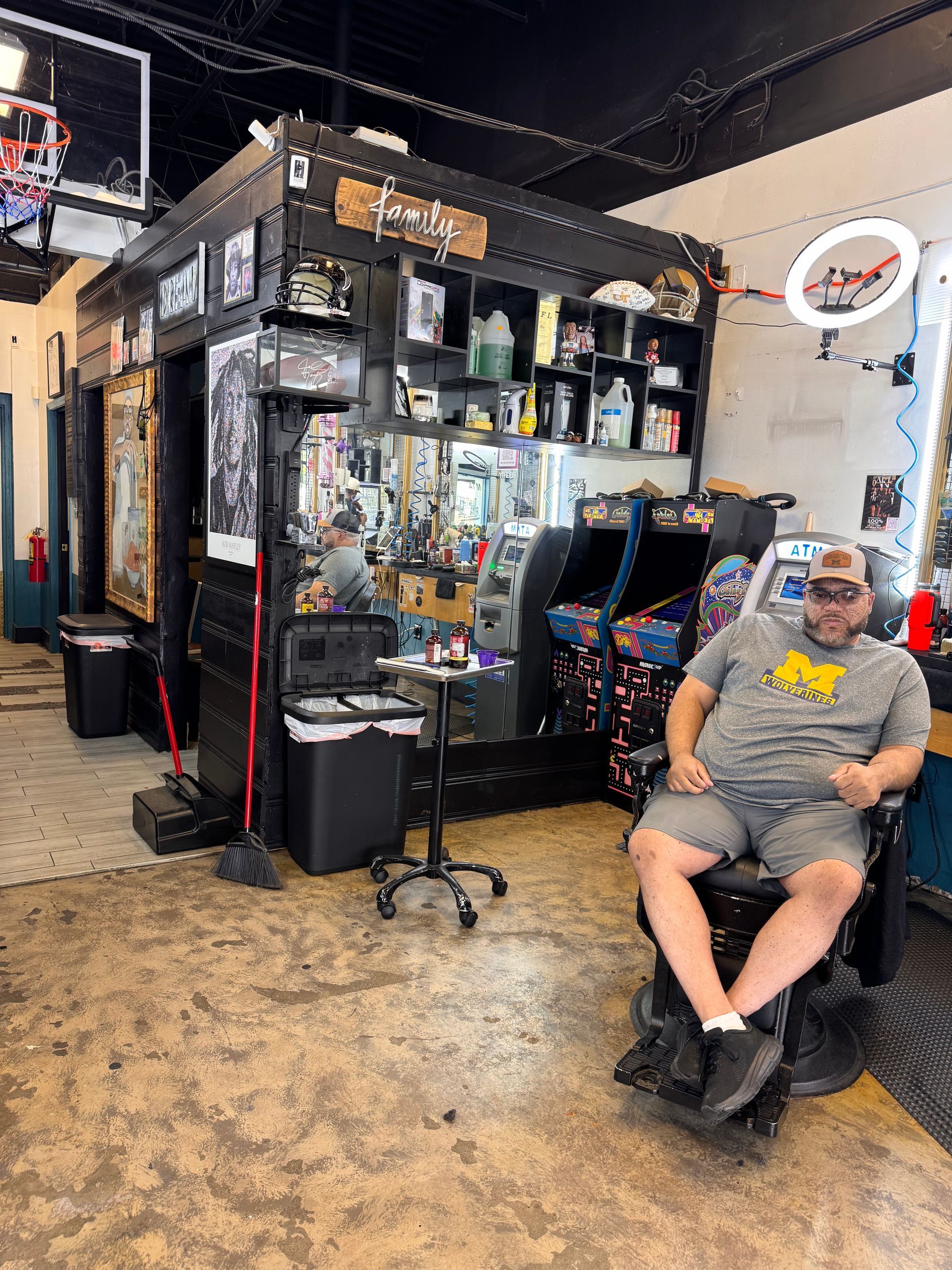 A man is sitting in a chair in a barber shop.