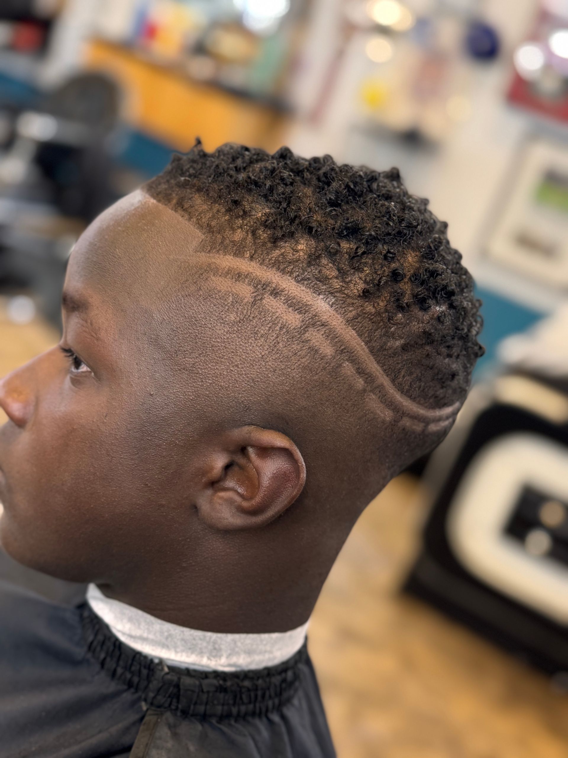 A young man is getting his hair cut at a barber shop