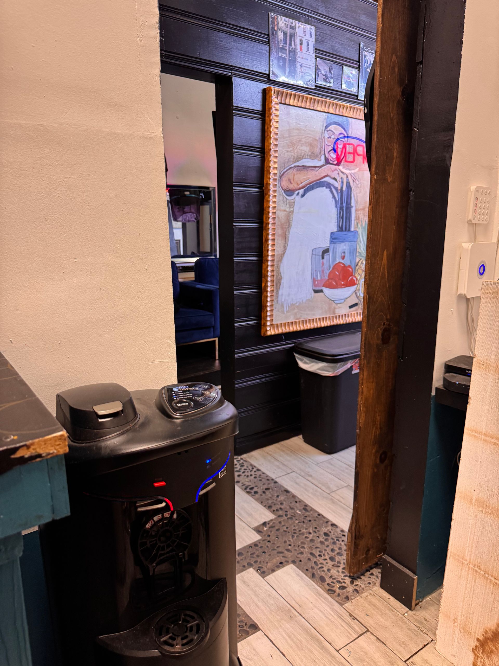A water dispenser is sitting next to a doorway in a room.