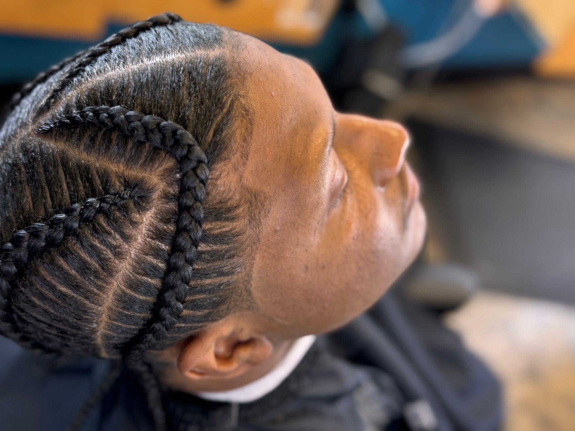 A close up of a person with braids in their hair