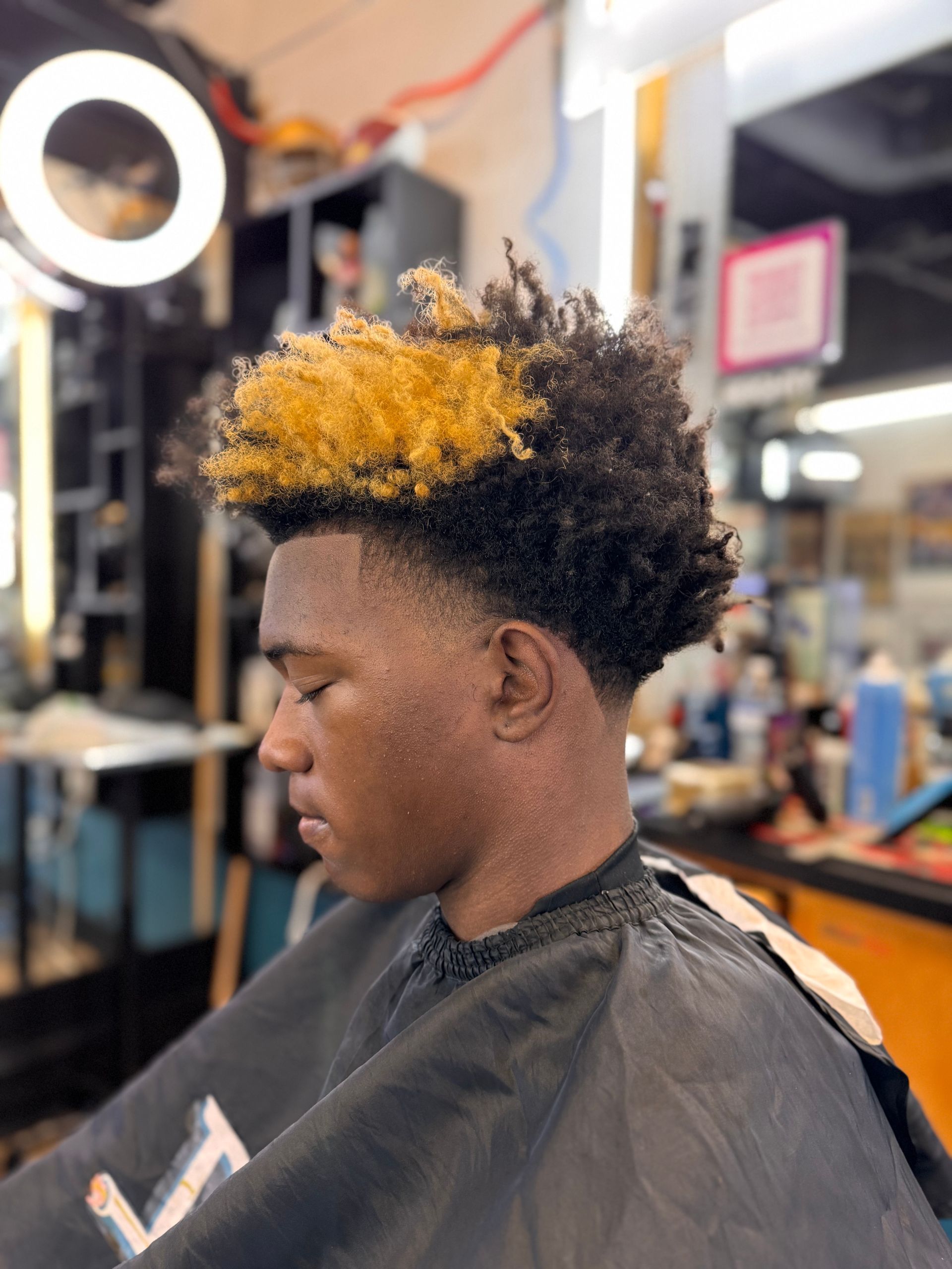 A man is getting his hair cut at a barber shop.