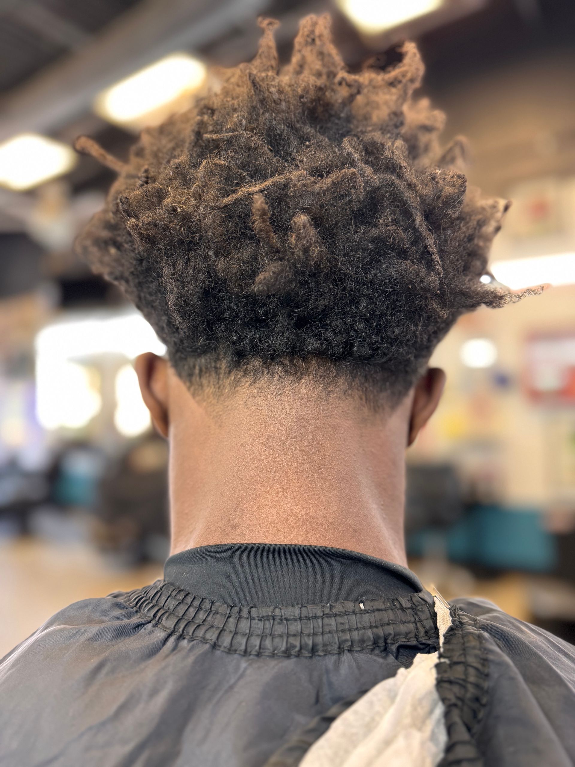 A man is getting his hair cut at a barber shop
