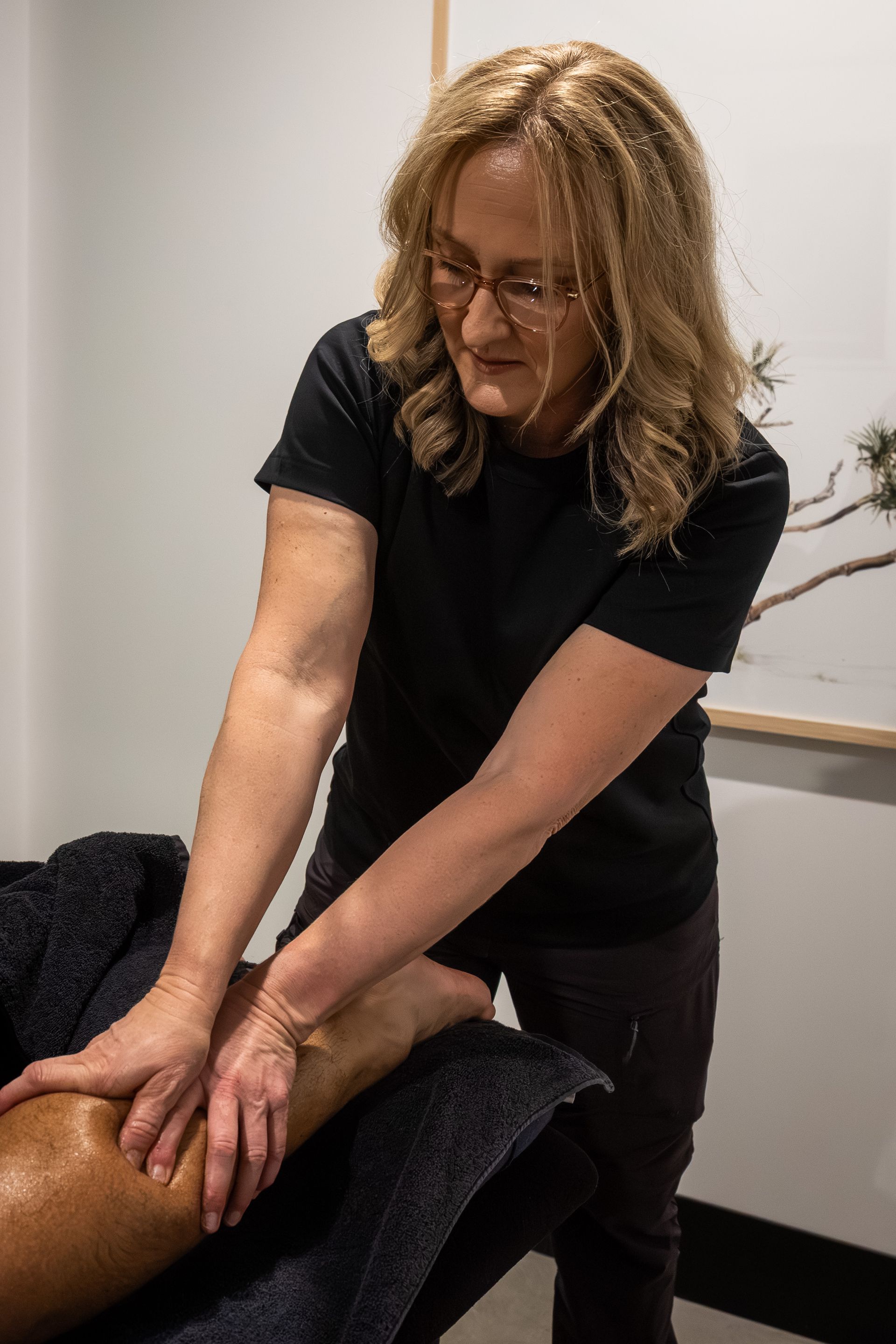 A woman is giving a massage to a man in a living room.