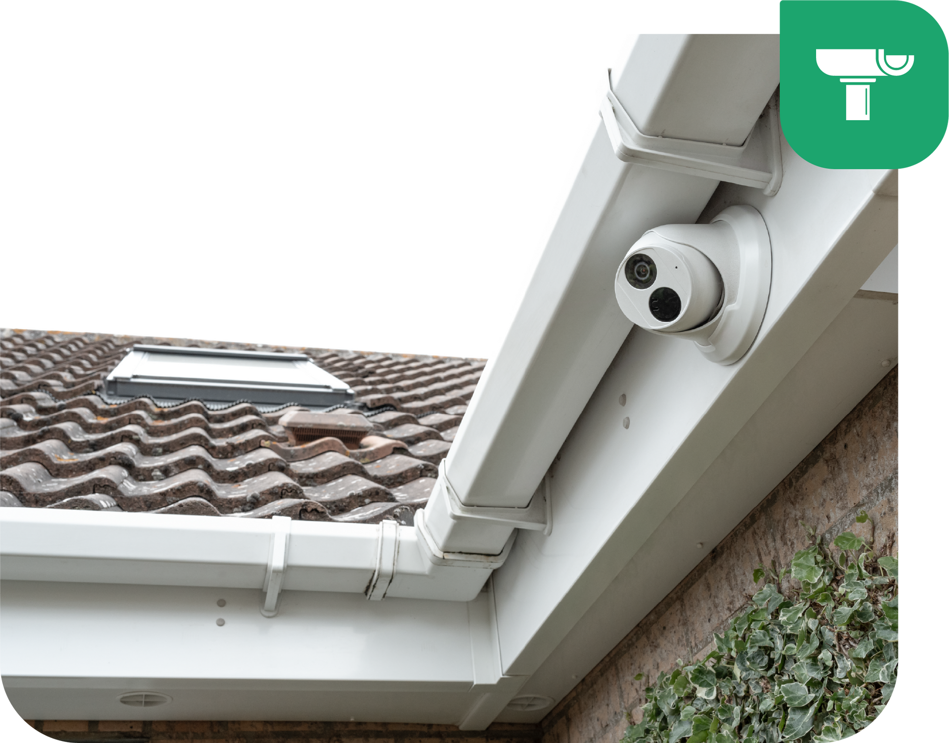White security camera mounted on a white roof gutter, overlooking a tiled roof and brick wall.