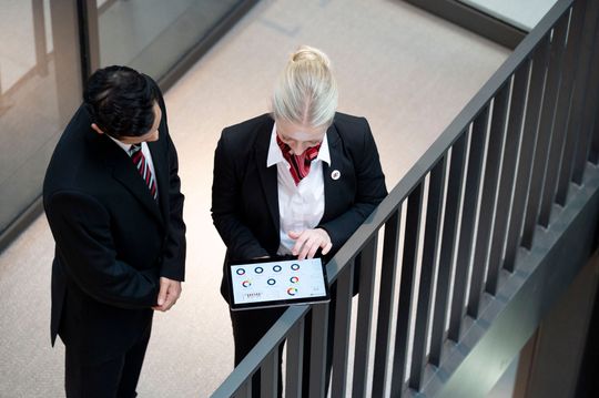 A man and a woman are looking at a tablet together