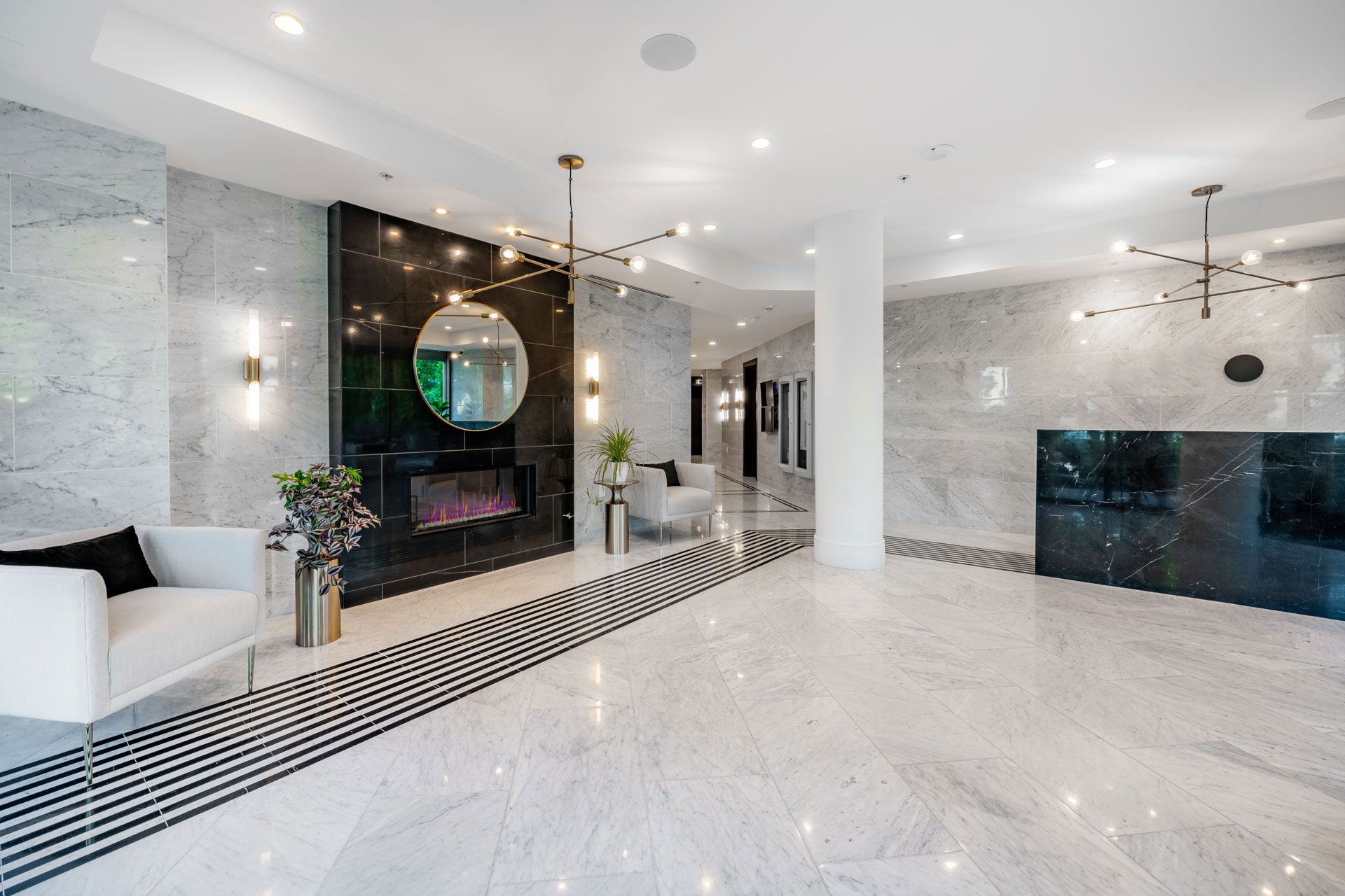 Bright modern lobby with marble floors, white seating, and black accent walls