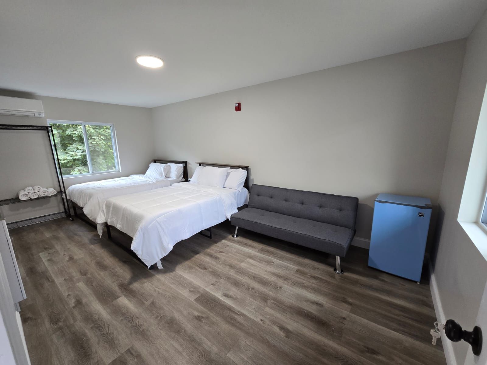 There are two beds and a couch in the room.
