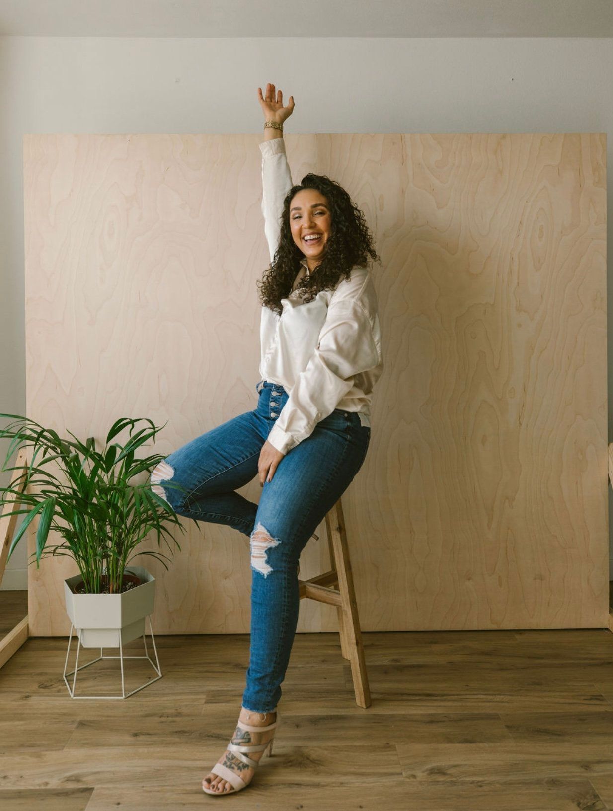 ashley, owner of mixed esthetics sitting on a stool