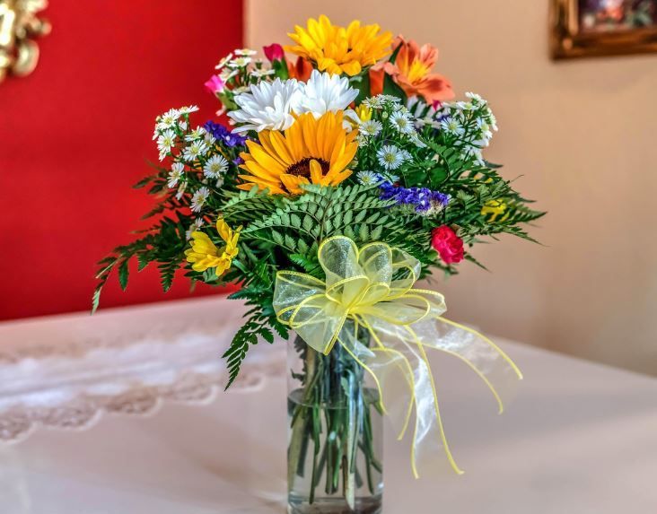 Colorful floral arrangement on table for casket types guide, funeral homes Moore, OK