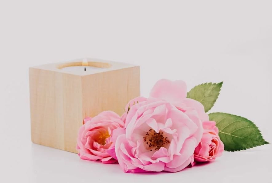 Memorial candle with pink roses on white backdrop, in-house direct cremation, cremation services Okl