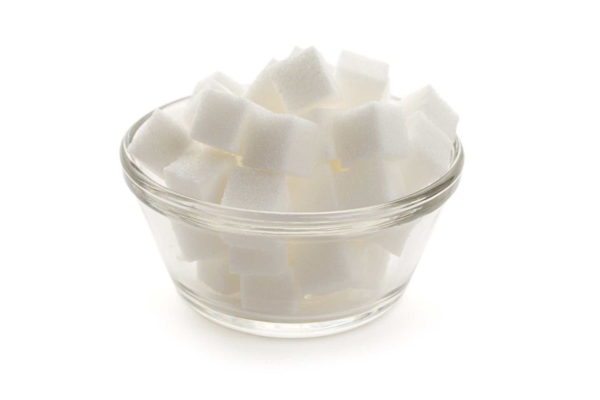 A bunch of sugar cubes in a glass bowl
