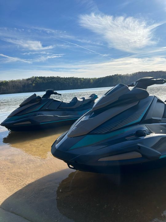 Two jet skis are parked on the shore of Lake Hartwell