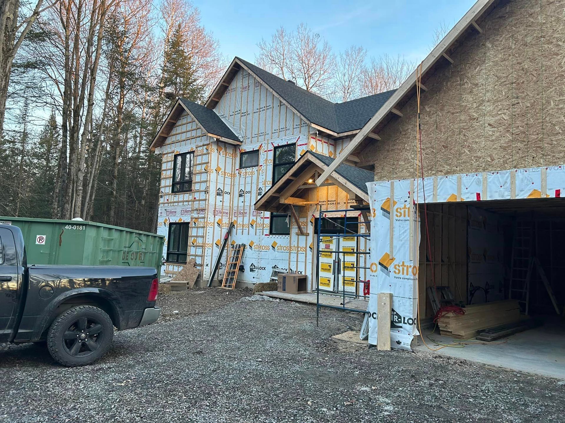 Un camion est garé devant une maison en construction.
