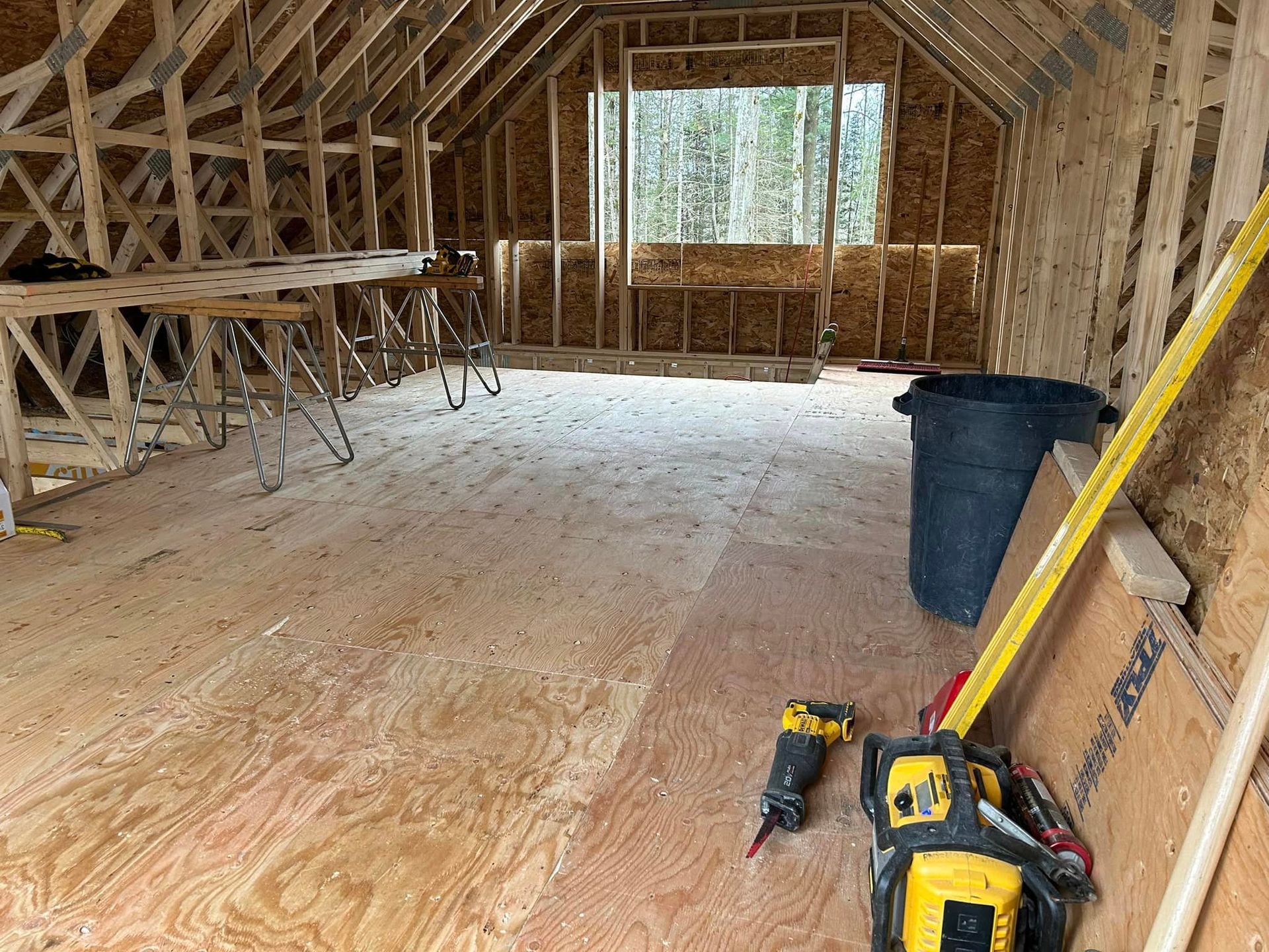 Une pièce en construction avec des outils et un ruban à mesurer au sol.