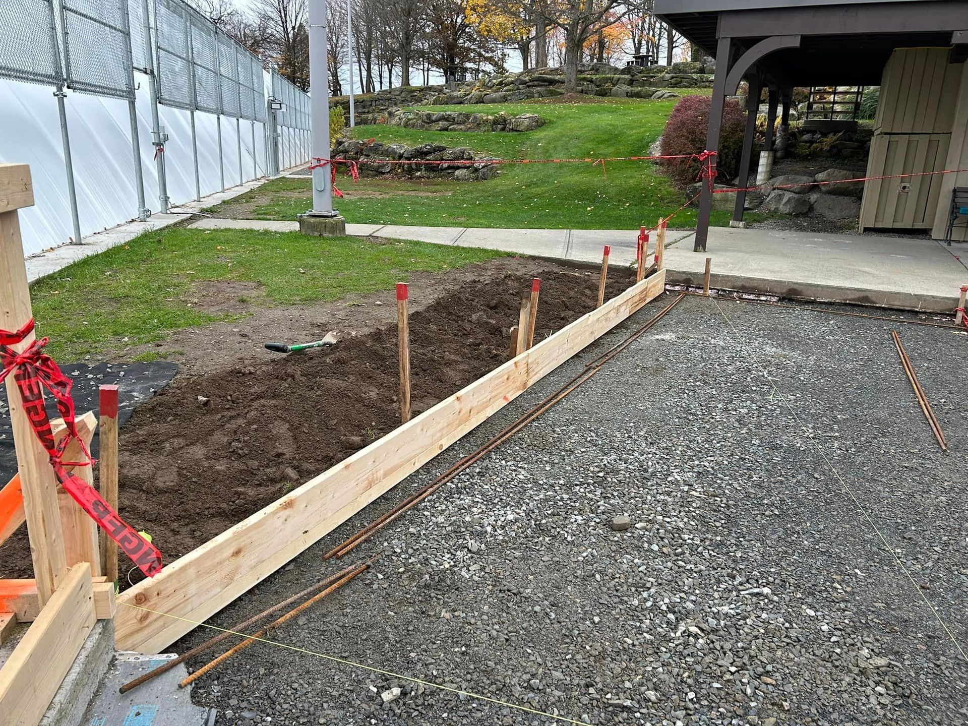 Une poutre en bois est posée sur un chemin de gravier.