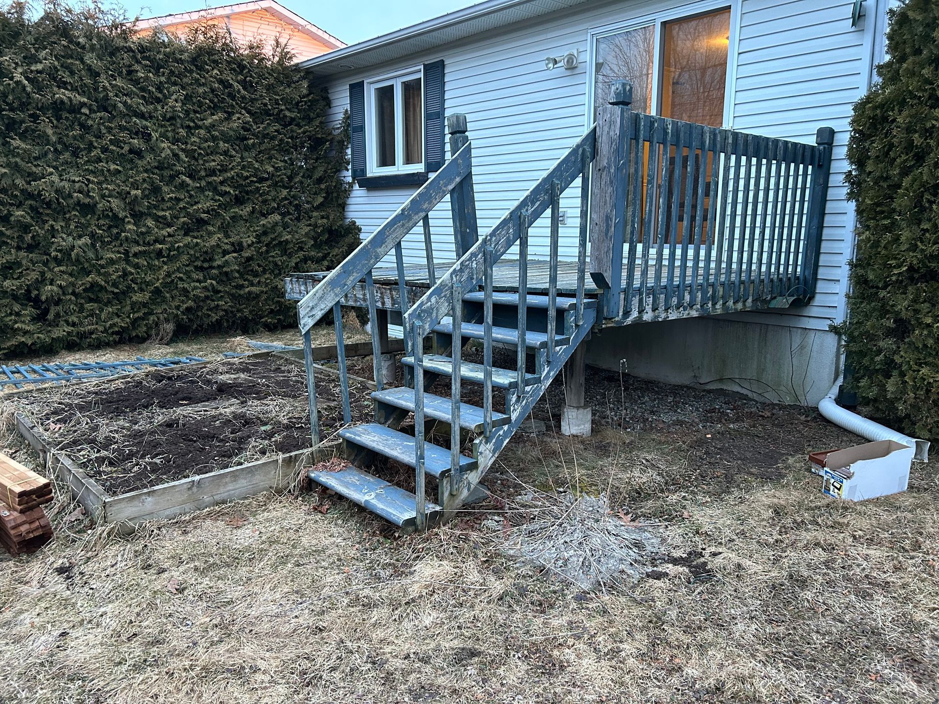 Une maison avec une terrasse et des escaliers devant.