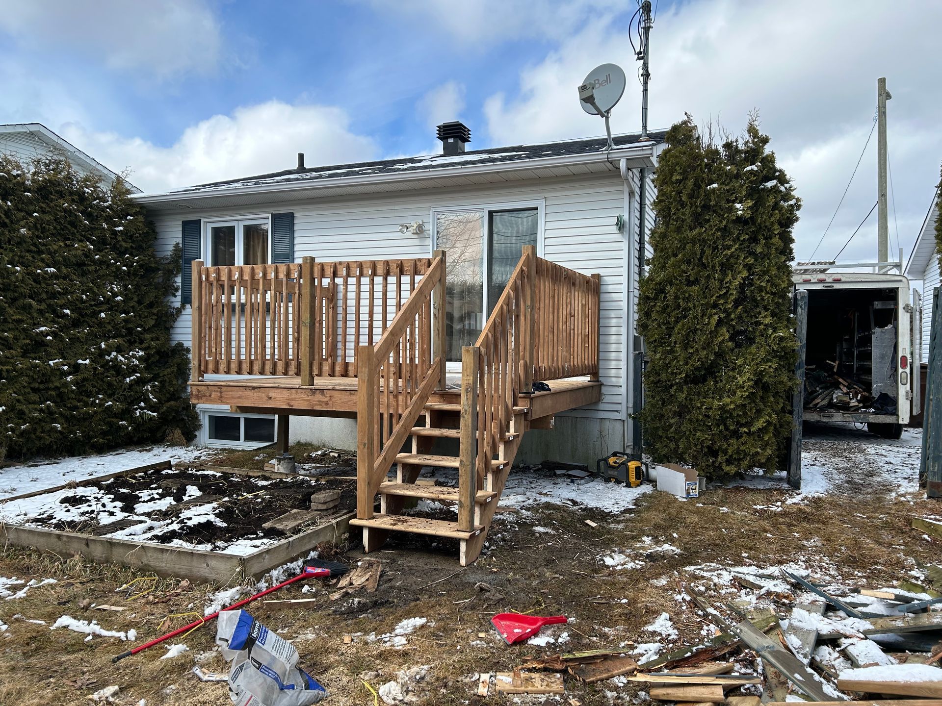 Une maison avec une terrasse en bois et des escaliers devant.