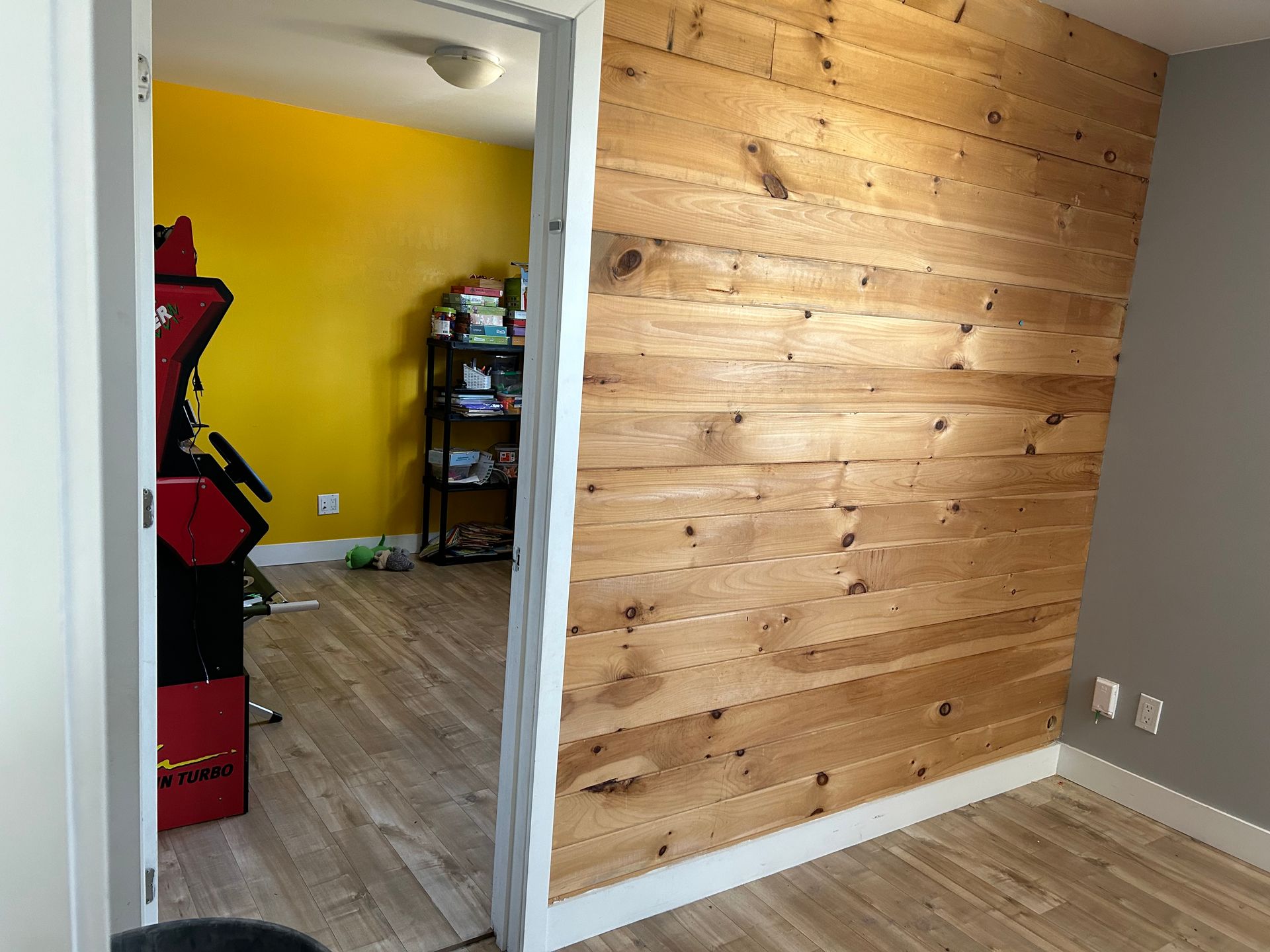 Une pièce avec un mur en bois et un mur jaune.
