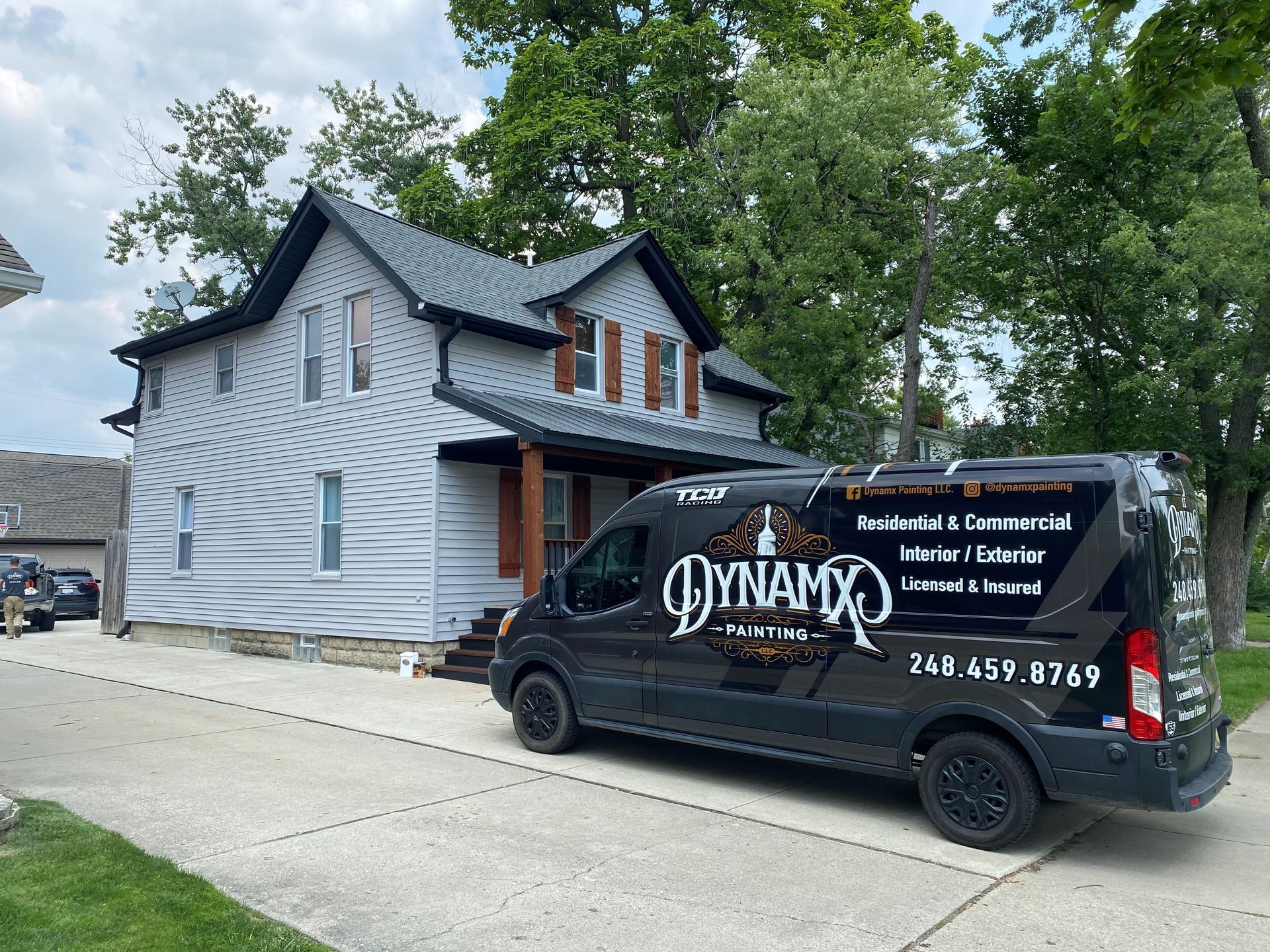 A black van is parked in front of a house.