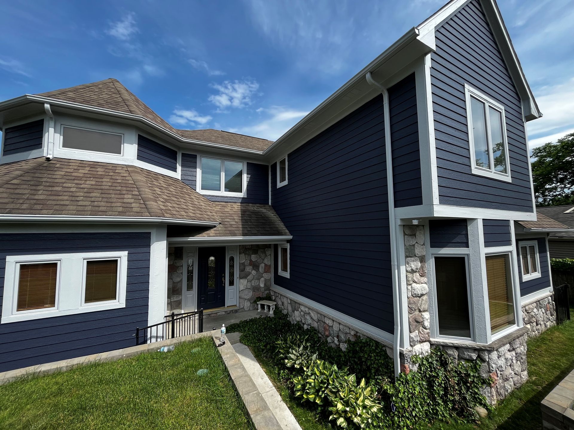 A large house with a blue siding and white trim