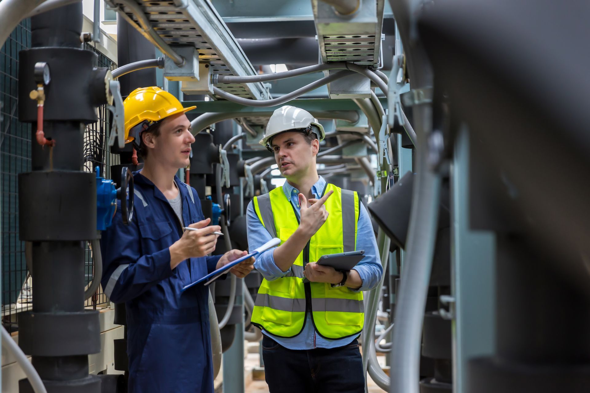 Two engineers, one in yellow hard hat.