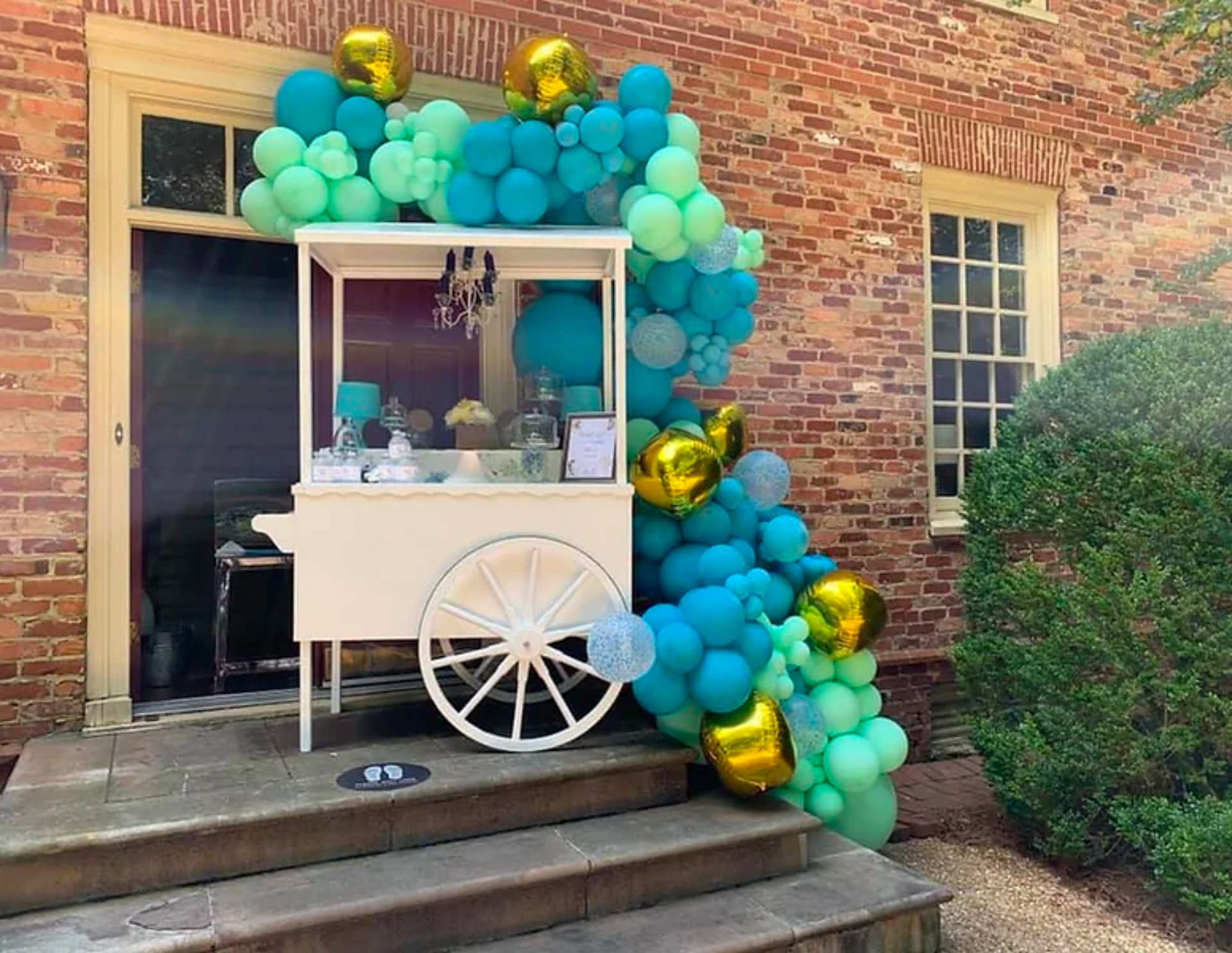 white candy cart with balloon garland