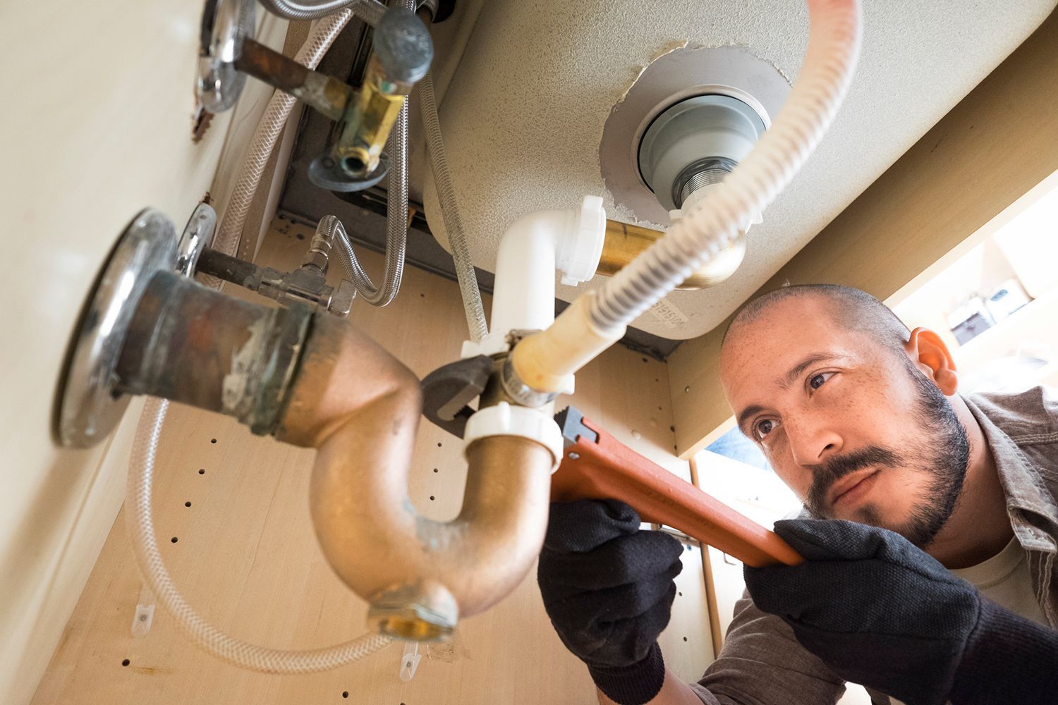A plumber working under the sink.