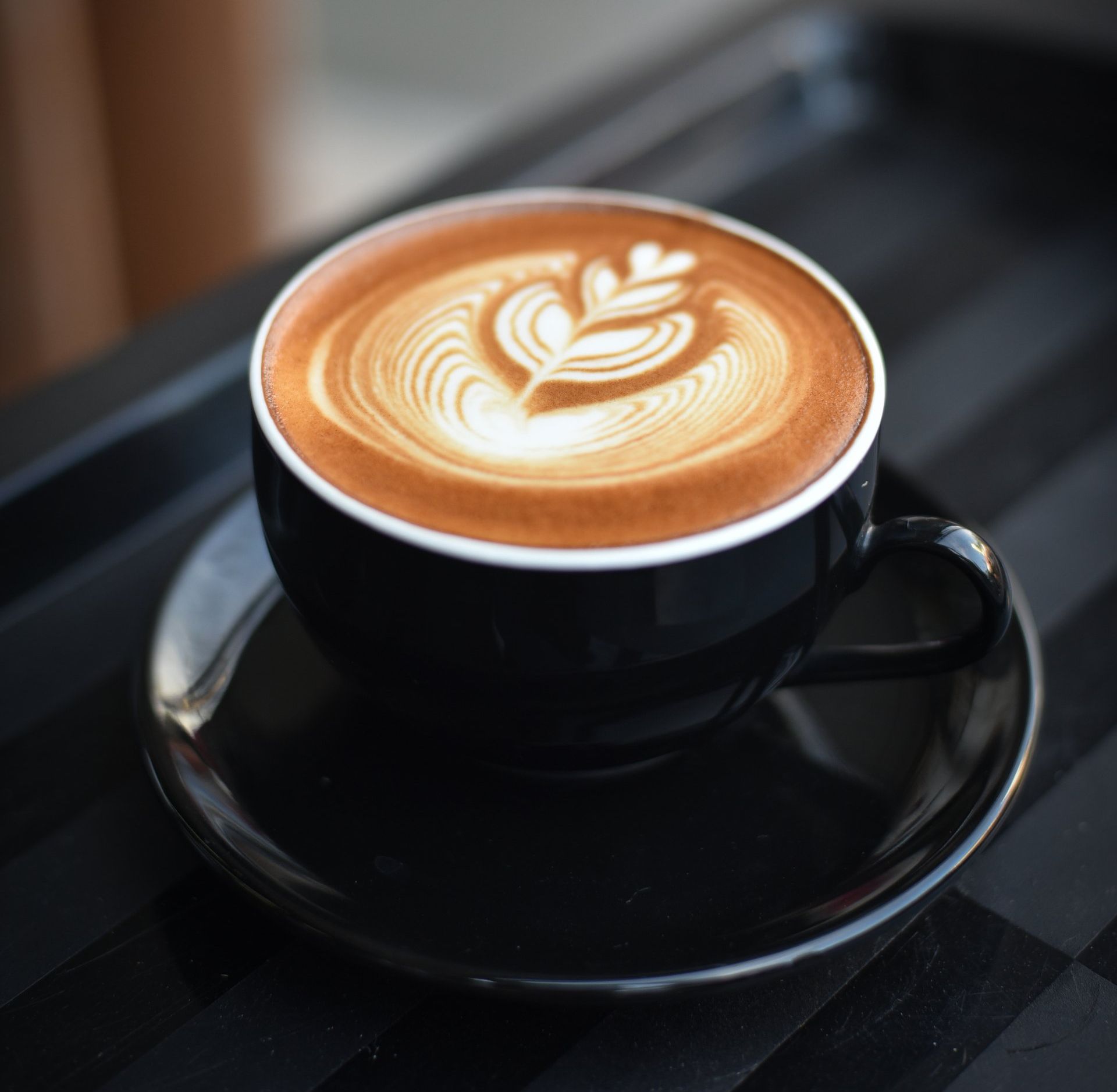 A cup of cappuccino on a saucer on a tray