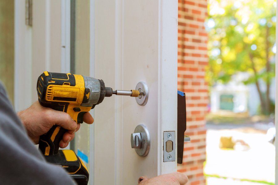 Worker's Hands Installing New Door Locker — Commerce, CA — Roca Lock & Key