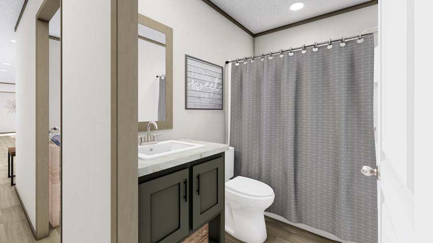 A bathroom with a toilet , sink , mirror and shower curtain.