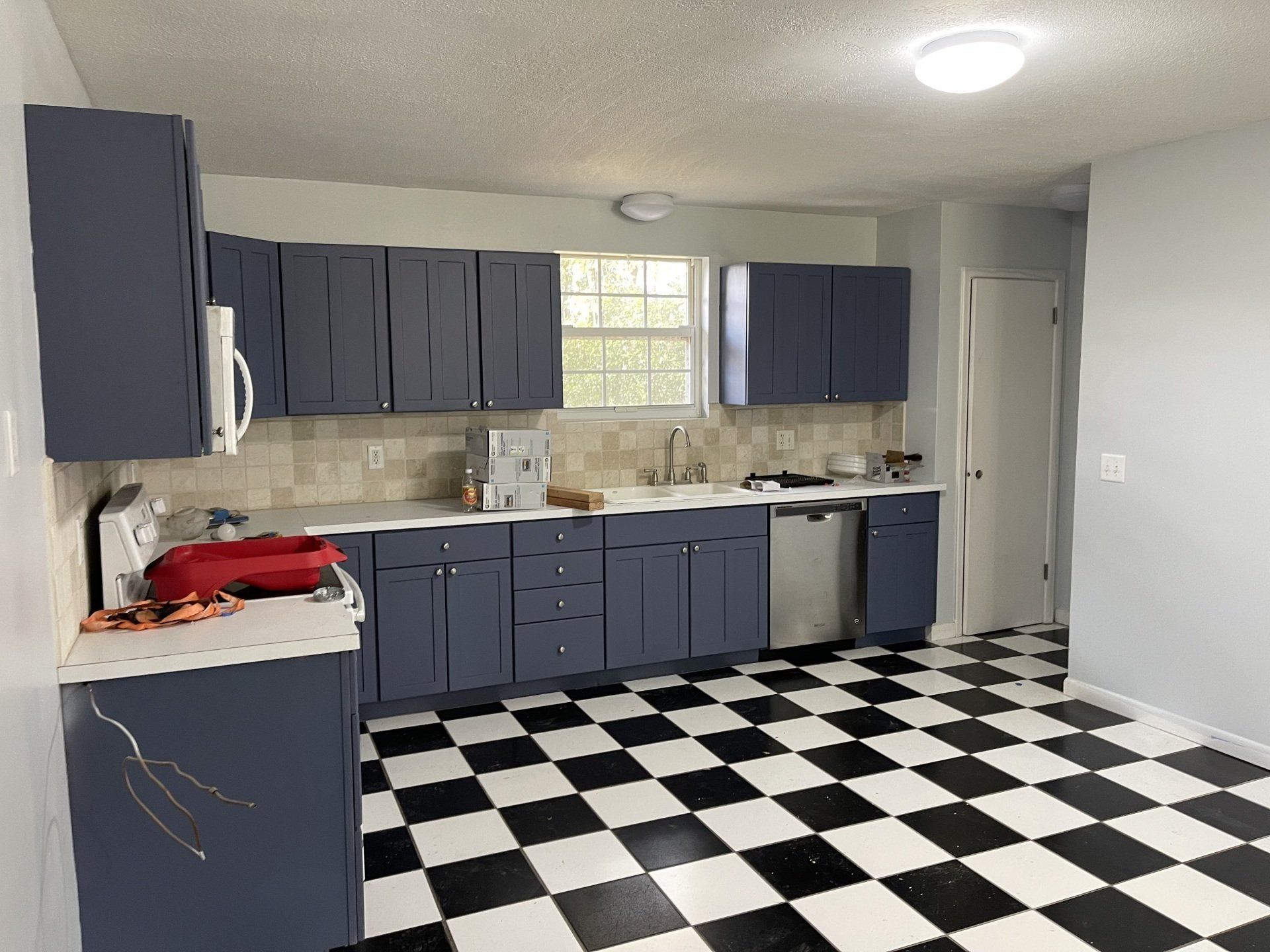 A kitchen with blue cabinets and a checkered floor