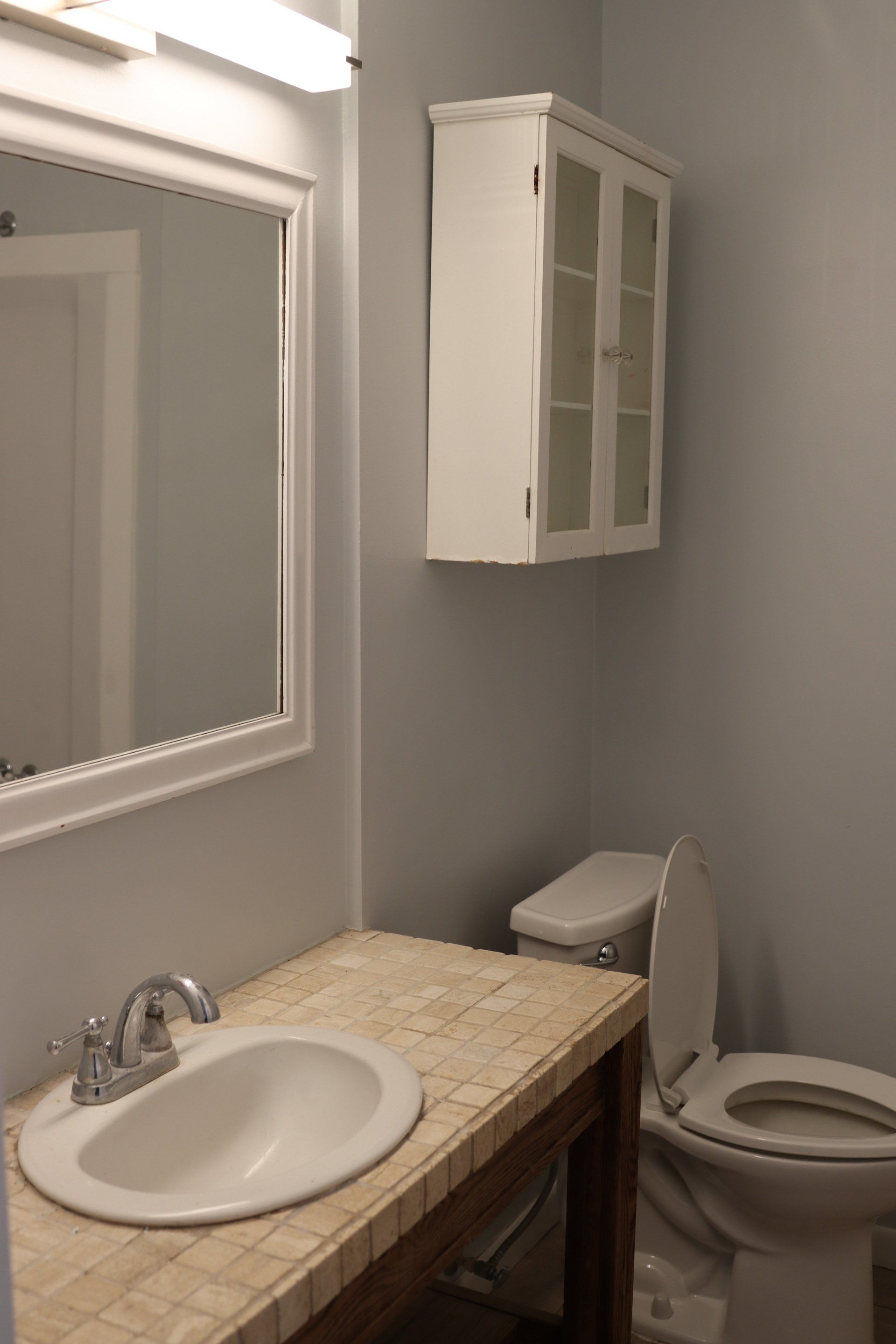 A bathroom with a sink , toilet and mirror