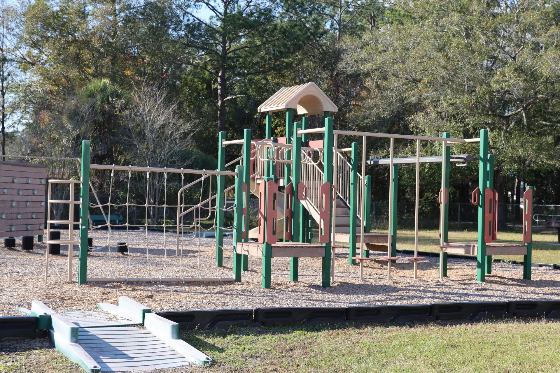 A playground with a ramp and trees in the background