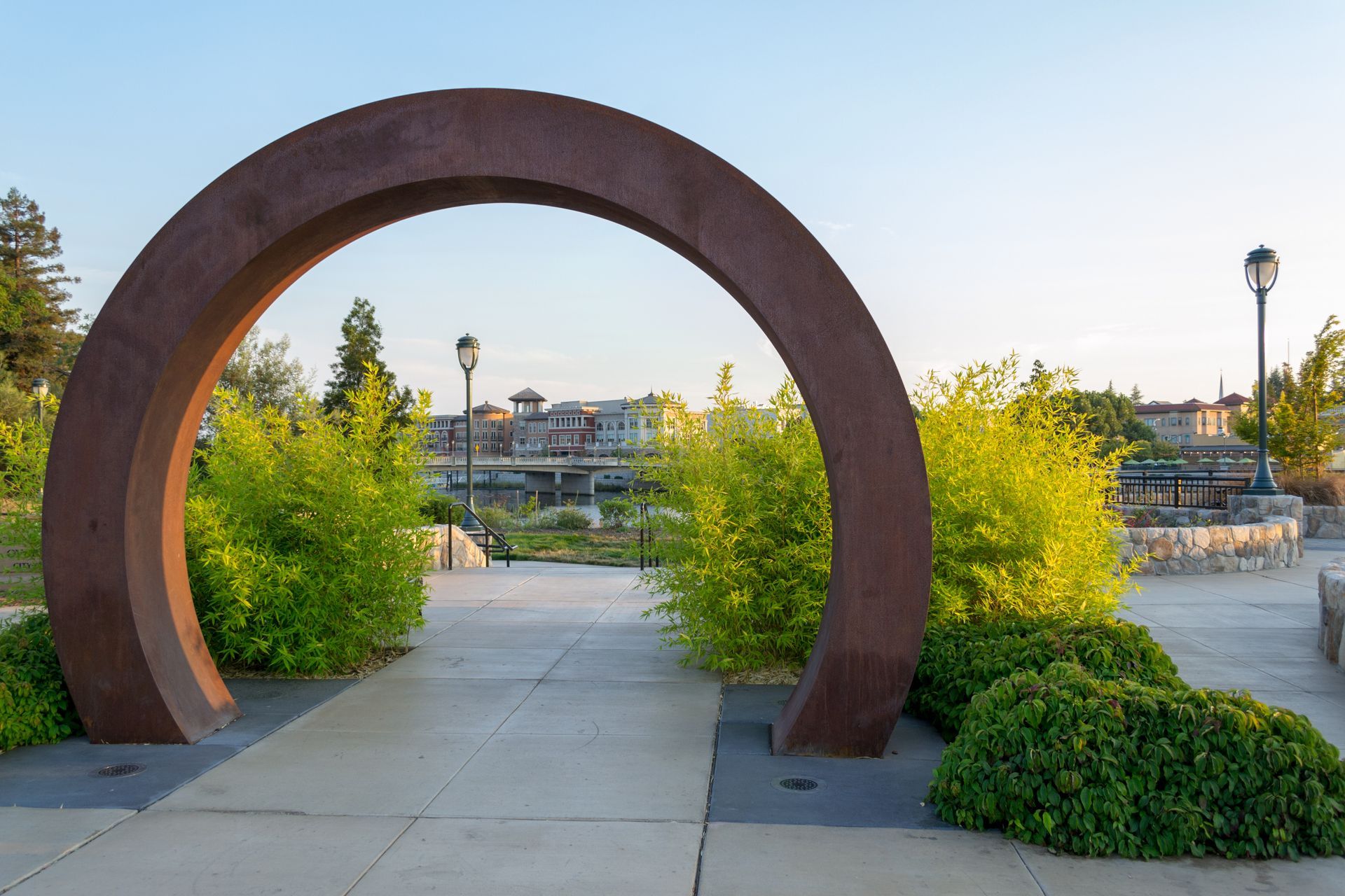 There is a large arch in the middle of a park.