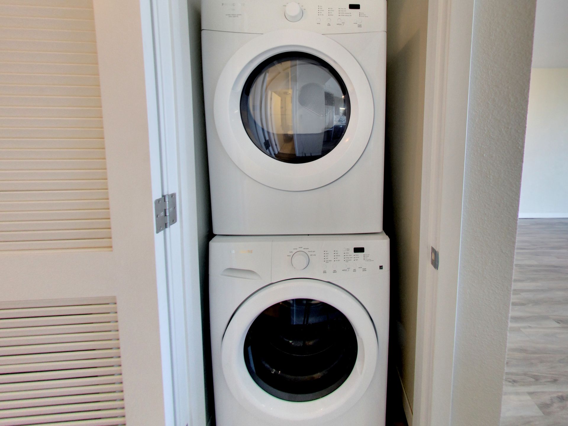 A washer and dryer are stacked on top of each other in a closet.