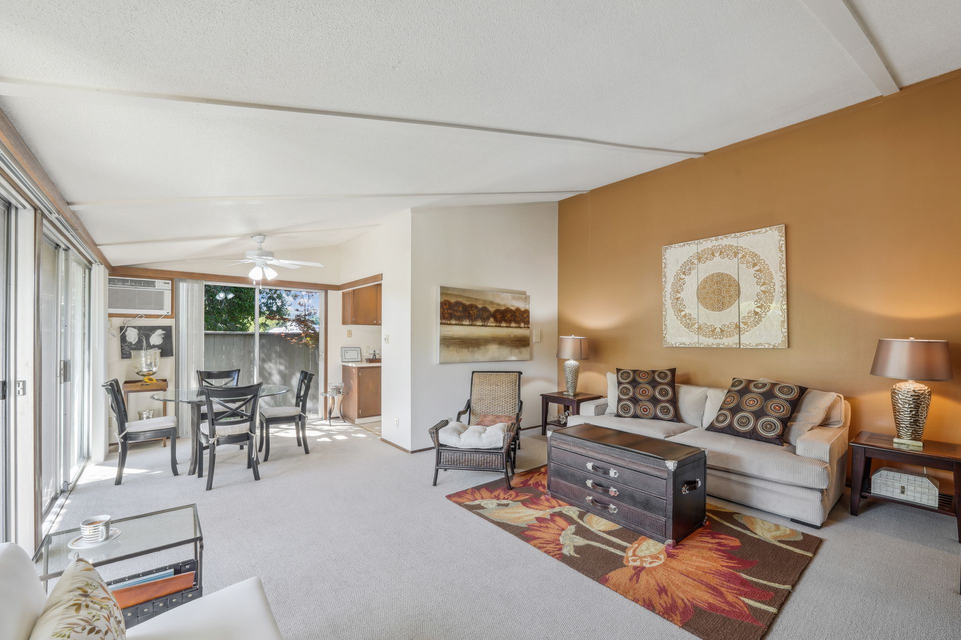 A living room with a couch , chairs , lamps and a rug.