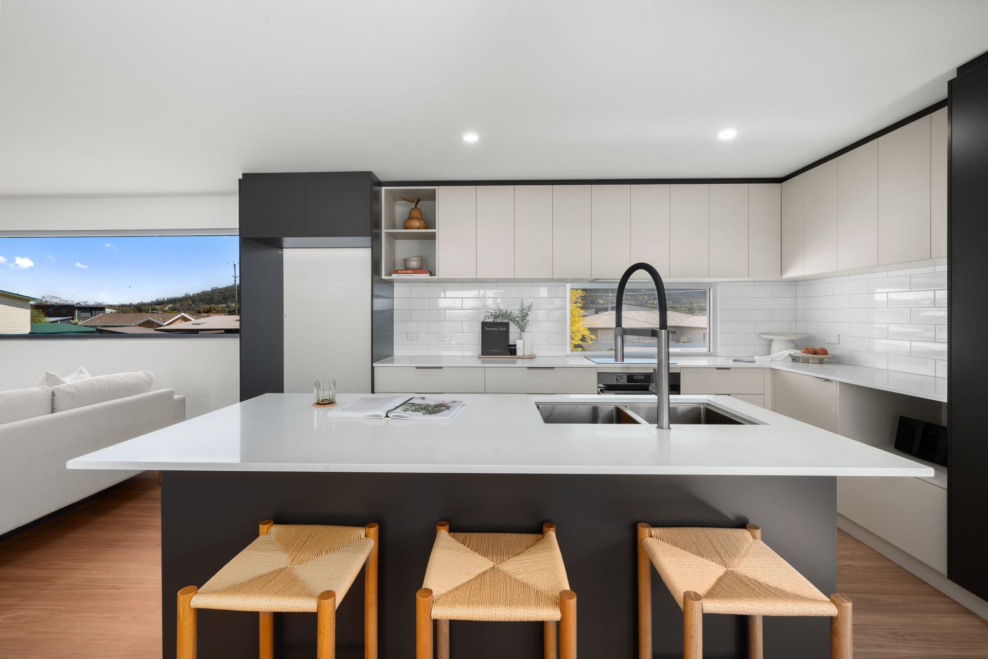 Plumber in white gloves, using a wrench to work on pipes under a sink.