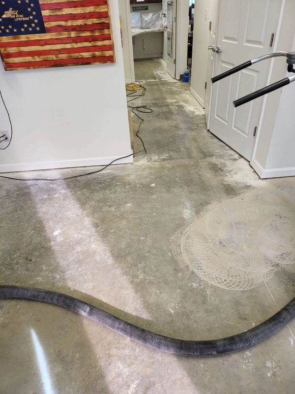Polished concrete floor being cleaned; tools and American flag in view.