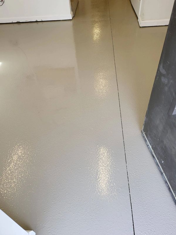 Gray epoxy flooring with a dark seam, indoors.