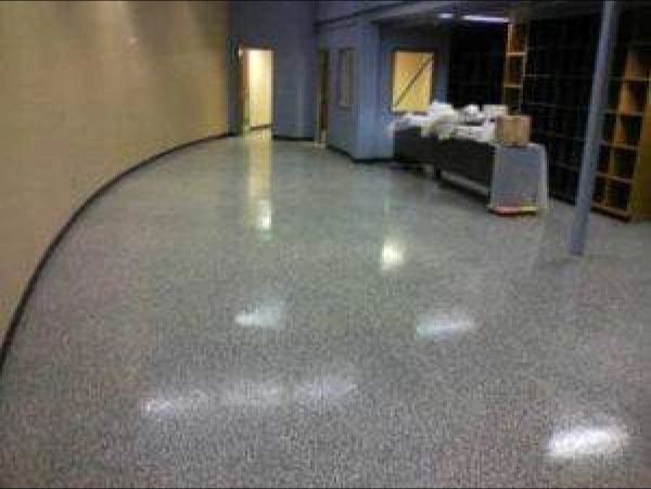 Shiny gray speckled floor in a room with doors, a desk, and shelves.