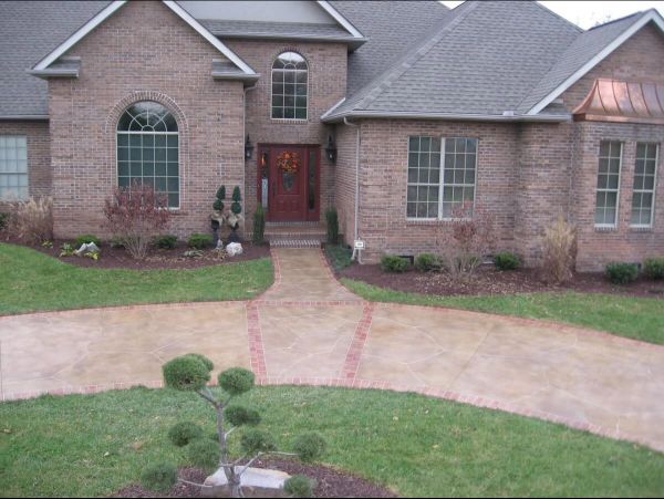 Brick house with curved driveway, front yard landscaping.