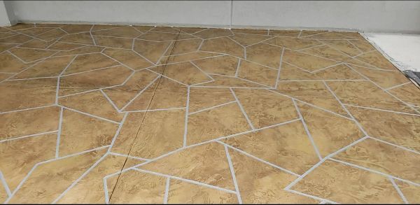 Brown floor with irregular, light-colored lines creating a geometric pattern.