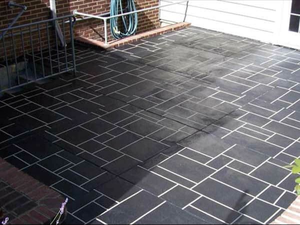Black patterned brick patio with white grout.