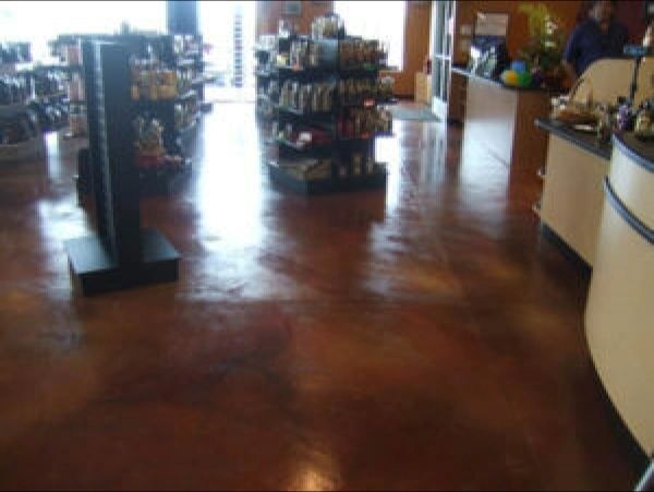A store interior with a shiny, brown floor, shelves with merchandise, and cream-colored counters.