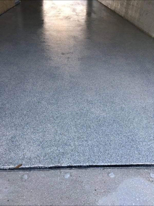Epoxy-coated garage floor with flecks of color, light gray color.