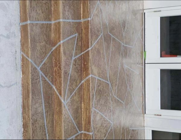 Wall with brown faux stone pattern, white grout, and white window frames.
