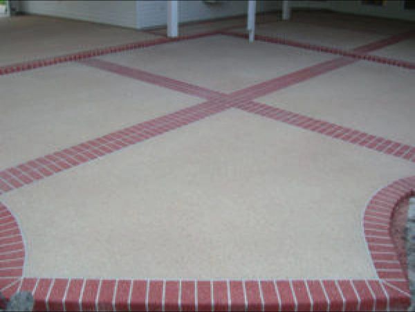 Concrete patio with brick border and intersecting brick lines.
