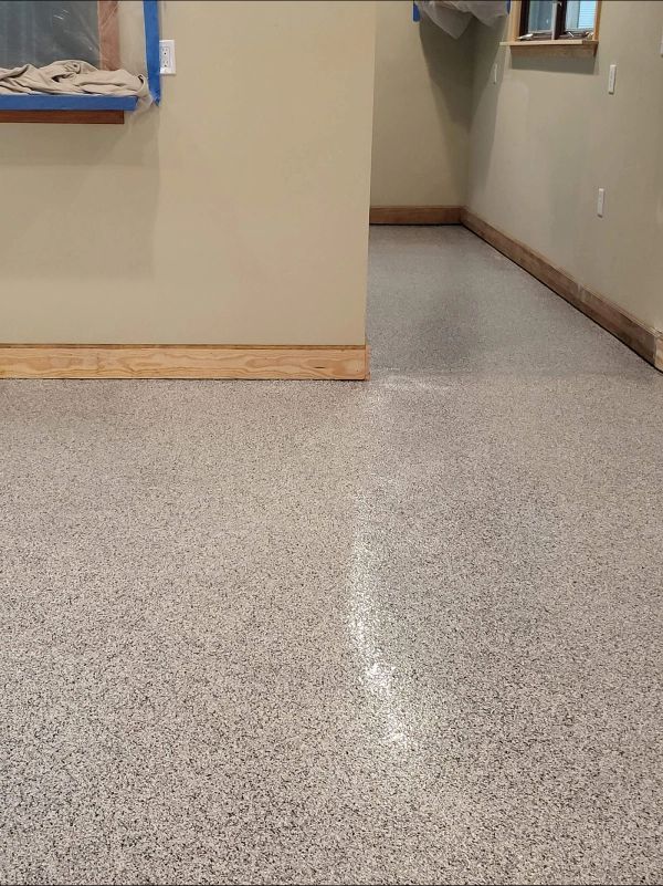 Gray speckled epoxy floor in a room with tan walls and wood trim.