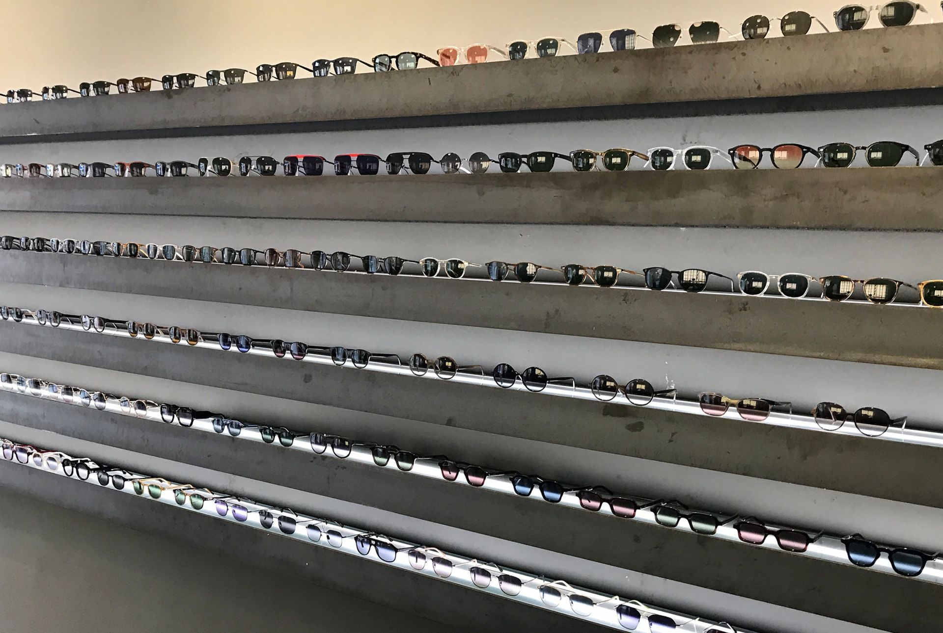 Brillen sind in einem Optikergeschäft auf mehreren Regalen ausgestellt.